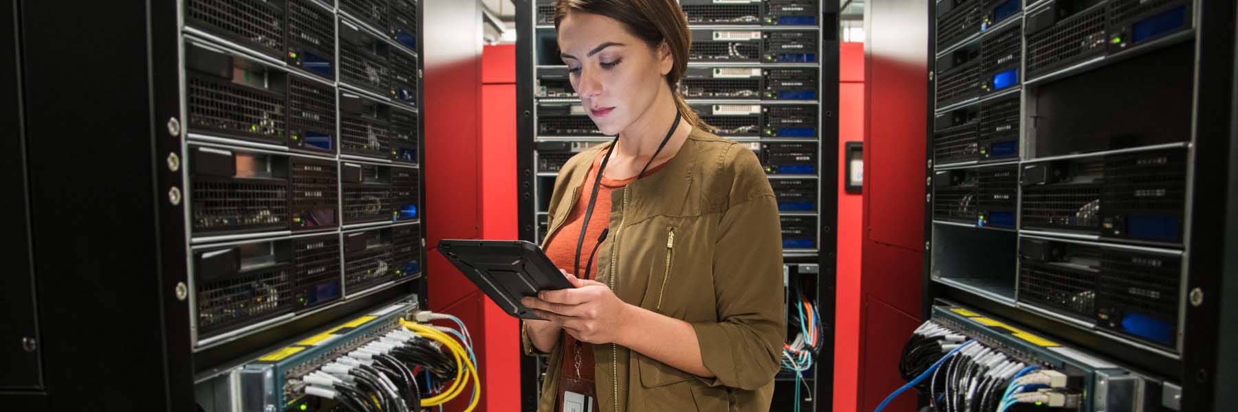 An IU employee works her tablet in a room of server stacks.